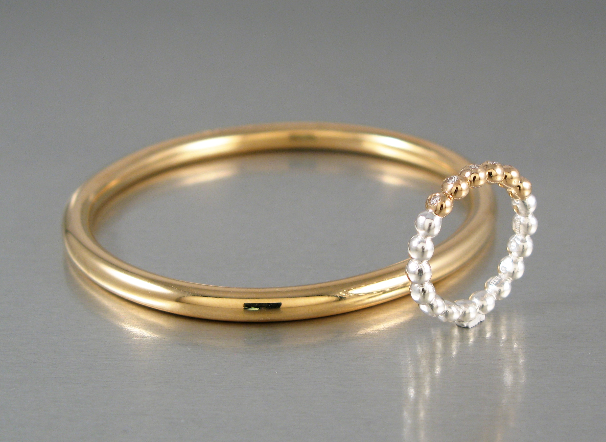 Ring, ”Kulring”, guld, silver, briljanter. Armring, guld.